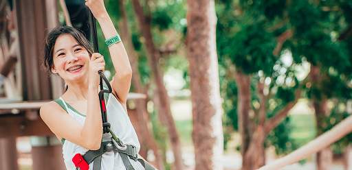 Happy participant enjoying the zipline adventure at Forest Adventure Big Zip Singapore